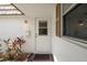 Close-up of the white front door with glass panel and a small front garden at 5521 Riverbluff Cir # V-10, Sarasota, FL 34231