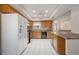 Well-lit kitchen featuring oak cabinets, white appliances, and practical layout at 5521 Riverbluff Cir # V-10, Sarasota, FL 34231