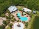 Aerial view of community amenities: clubhouse, pools, volleyball, basketball, playgrounds, seating areas all with lush landscape at 5740 Sunflower Cir, Sarasota, FL 34238