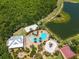 Overhead perspective of community amenities including a pool, playground, and recreation area amidst lush landscaping and a pond at 5740 Sunflower Cir, Sarasota, FL 34238