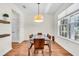 Cozy dining room with hardwood floors, chandelier, modern table with six chairs and view of the backyard at 5740 Sunflower Cir, Sarasota, FL 34238