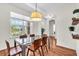 Bright dining room with hardwood floors, natural light, modern table with chairs and plant shelves at 5740 Sunflower Cir, Sarasota, FL 34238