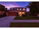 Two-story home with a two-car garage and well-manicured lawn at dusk at 5740 Sunflower Cir, Sarasota, FL 34238