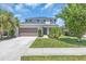 Charming two-story home boasts a well-manicured lawn, lush landscaping, and an attached two-car garage at 5740 Sunflower Cir, Sarasota, FL 34238