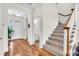 Bright foyer with hardwood floors, staircase, and access to a half-bathroom and the front door at 5740 Sunflower Cir, Sarasota, FL 34238
