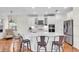 Modern kitchen with white cabinetry, stone countertops, stainless appliances and island with seating at 5740 Sunflower Cir, Sarasota, FL 34238