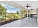 Covered and screened patio with white wood floors, ceiling fans and a peaceful nature view at 5740 Sunflower Cir, Sarasota, FL 34238