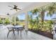Relaxing screened-in porch featuring tile flooring, ceiling fans, outdoor seating, and views of lush landscaping at 5740 Sunflower Cir, Sarasota, FL 34238
