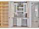Elegant bar area with custom cabinetry, beverage refrigerator, and decorative lighting, perfect for entertaining guests at 5939 Redbay Blvd, Bradenton, FL 34210