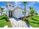Modern home exterior featuring a paved walkway, manicured lawn, and lush tropical landscaping at 5939 Redbay Blvd, Bradenton, FL 34210