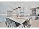 Modern white kitchen featuring a large island with counter seating, stainless steel appliances, and ample cabinet space at 5939 Redbay Blvd, Bradenton, FL 34210