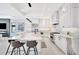 Bright kitchen with sleek white cabinetry, a spacious island with seating, stainless steel appliances, and modern lighting at 5939 Redbay Blvd, Bradenton, FL 34210