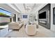 Bright, open living room with modern fireplace, TV, and sliding doors to an outdoor space at 5939 Redbay Blvd, Bradenton, FL 34210