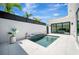 Modern pool area featuring sleek pool design, white tile, and views of the home's interior through glass doors at 5939 Redbay Blvd, Bradenton, FL 34210