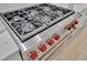 Close-up of a professional-grade six-burner gas range with stainless steel finish and red knobs at 5939 Redbay Blvd, Bradenton, FL 34210