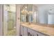 Bright bathroom featuring a marble countertop, mirrored wall, vanity and a shower with glass doors at 6157 Midnight Pass Rd # B42, Sarasota, FL 34242