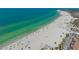 A stunning beach view with white sand, beach umbrellas, and calm, turquoise ocean waters at 6157 Midnight Pass Rd # B42, Sarasota, FL 34242