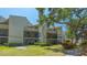 Well maintained exterior featuring a lush green lawn, mature landscaping, and private screened in balconies at 6157 Midnight Pass Rd # B42, Sarasota, FL 34242