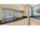 The pass through to the dining room features light wood cabinets, dark countertops, and tile backsplash at 6157 Midnight Pass Rd # B42, Sarasota, FL 34242