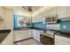 Bright kitchen with stainless steel appliances, light wood cabinets, and dark countertops at 6157 Midnight Pass Rd # B42, Sarasota, FL 34242