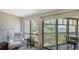 Bright living room featuring a wall of windows offering serene water views and access to a private balcony at 6157 Midnight Pass Rd # B42, Sarasota, FL 34242
