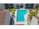 Aerial view of community pool surrounded by palm trees and lounge chairs for residents' enjoyment at 6157 Midnight Pass Rd # B42, Sarasota, FL 34242