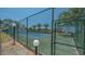 Well-maintained tennis court available for residents, surrounded by lush greenery and palm trees at 6157 Midnight Pass Rd # B42, Sarasota, FL 34242