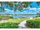 Community waterfront area featuring a dock, walkway, and lush green grass and landscaping for residents' enjoyment at 6157 Midnight Pass Rd # B42, Sarasota, FL 34242