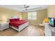This bedroom features a tray ceiling, a window with plantation shutters, and hardwood floors at 6713 Chester Trl, Bradenton, FL 34202