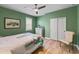 Green bedroom features hardwood floors and a large window overlooking the front yard at 6713 Chester Trl, Bradenton, FL 34202