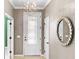 Elegant entryway featuring a decorative glass door, stylish light fixture, and decorative wall mirror at 6713 Chester Trl, Bradenton, FL 34202