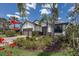 Beautifully landscaped front yard with blooming red flowers, brick driveway, and stone-accented one-story home at 6713 Chester Trl, Bradenton, FL 34202