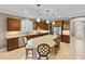 Spacious kitchen featuring dark wood cabinetry, an expansive island, stainless appliances, and barstool seating at 6713 Chester Trl, Bradenton, FL 34202