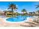Resort-style pool with ample lounge space, palm trees, and a clubhouse in the background at 6713 Chester Trl, Bradenton, FL 34202