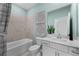 Tranquil, neutral-toned bathroom featuring a shower-tub combo, sleek white vanity, and light turquoise walls at 8134 Shore Lake Dr, Englewood, FL 34224