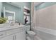 Bright bathroom featuring a white vanity, toilet, and bathtub with tiled shower, complemented by stylish decor at 8134 Shore Lake Dr, Englewood, FL 34224