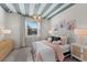 Charming bedroom with pastel bedding, custom ceiling decor, and stylish lighting fixtures on bedside tables at 8134 Shore Lake Dr, Englewood, FL 34224
