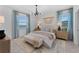 Serene bedroom with a soft color palette, stylish lighting, and a beautiful view from the large windows at 8134 Shore Lake Dr, Englewood, FL 34224