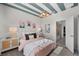 Stylish bedroom with blue striped ceiling, complemented by pastel bedding and modern lighting on bedside tables at 8134 Shore Lake Dr, Englewood, FL 34224