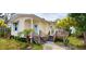 Charming home with pale yellow siding, a baby blue front door, and a raised deck with steps leading down to the yard at 8297 Strasse Blvd, Punta Gorda, FL 33982