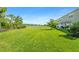 Sprawling backyard boasts lush greenery, mature trees, and a picturesque pond view, perfect for nature lovers at 8596 Lunar Skye St, Sarasota, FL 34241