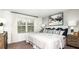 Relaxing bedroom with a cozy queen-size bed, soft lighting, and a large window with natural light at 8596 Lunar Skye St, Sarasota, FL 34241