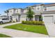 Inviting townhouse complex with one-car garages, blue doors, and a green lawn at 8596 Lunar Skye St, Sarasota, FL 34241