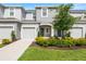 Lovely townhomes with a well-manicured lawn and garden leading to blue front doors at 8596 Lunar Skye St, Sarasota, FL 34241