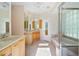 Bright bathroom featuring double sinks, soaking tub, glass enclosed shower, and tile flooring at 9120 Willow Brook Dr, Sarasota, FL 34238