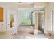 Bright bathroom with a soaking tub, glass enclosed shower, and tile flooring at 9120 Willow Brook Dr, Sarasota, FL 34238