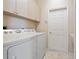 This laundry room features a tile floor, lots of storage, and a utility sink right next to the door at 9120 Willow Brook Dr, Sarasota, FL 34238