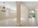 Spacious living room with tile flooring, a chandelier, and natural light at 9120 Willow Brook Dr, Sarasota, FL 34238