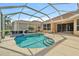 This spacious screened-in pool area features a pool, jacuzzi, and plenty of room to lounge at 9120 Willow Brook Dr, Sarasota, FL 34238