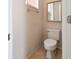 Clean and simple powder room with a toilet, mirror, and tiled floor at 9120 Willow Brook Dr, Sarasota, FL 34238